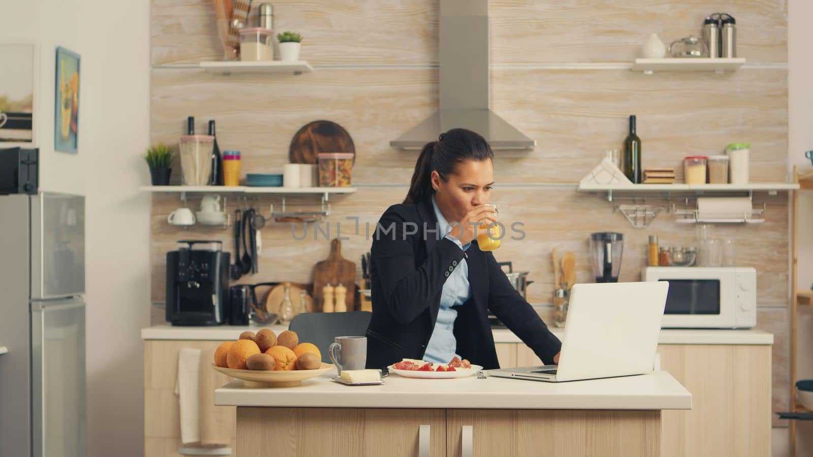 Business woman eating breakfast by DCStudio