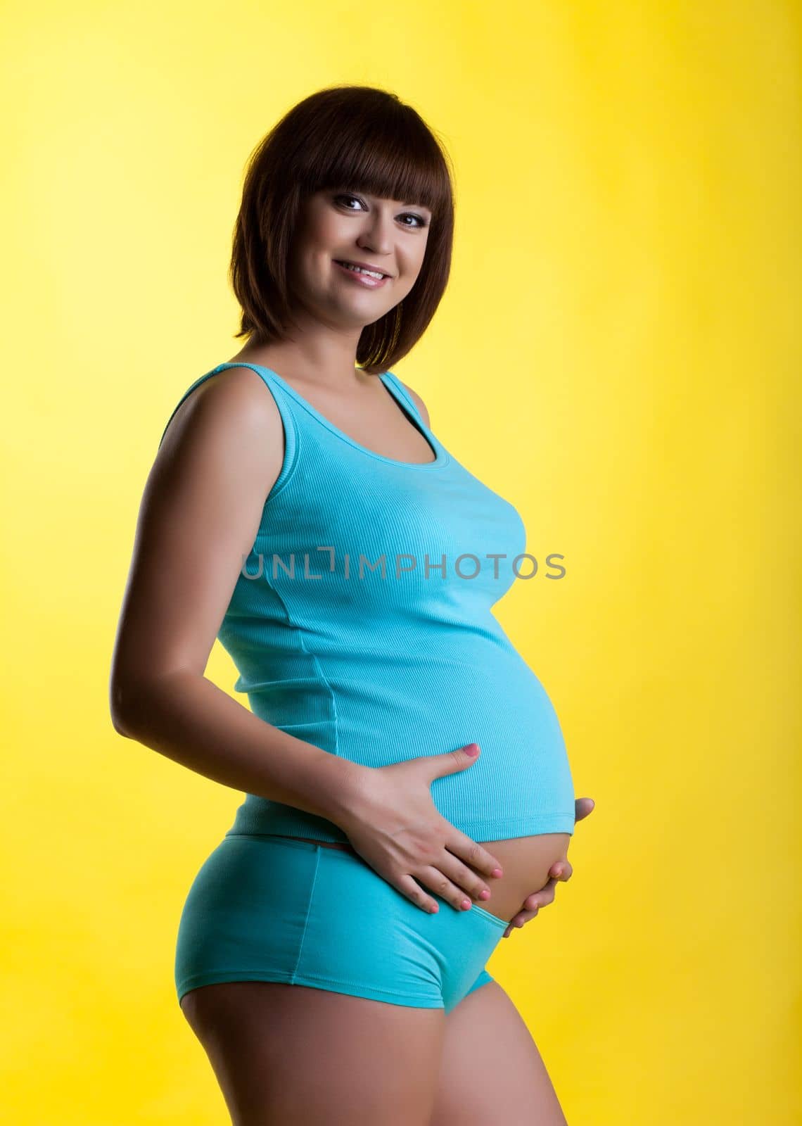 Pretty pregnant young woman smiling by rivertime