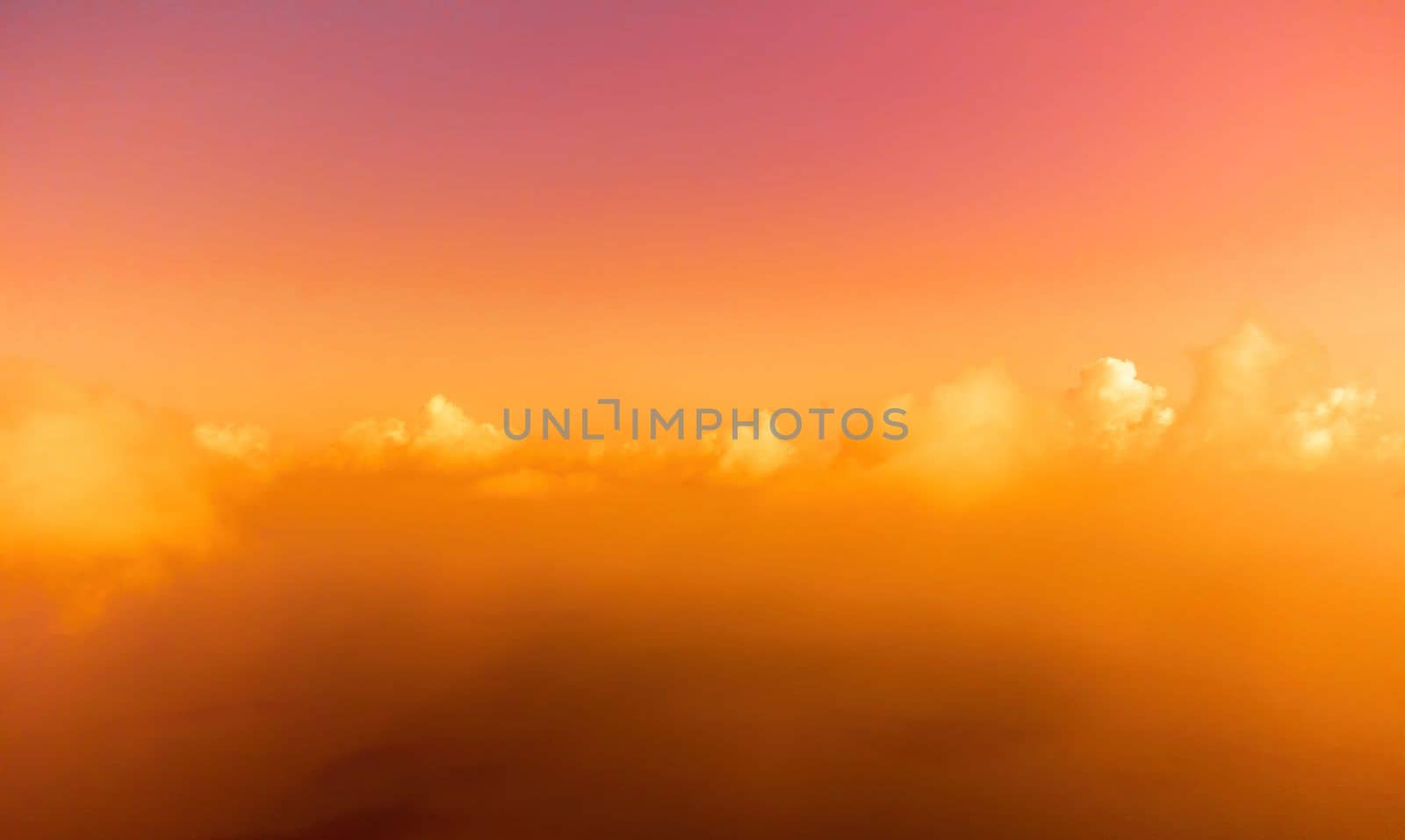 Aerial view red burning sunset over the sea with rocky volcanic cliff. Abstract nature summer sunset ocean sea background. Small waves on golden warm water surface Evening. Horizon. Nobody. No people. by panophotograph