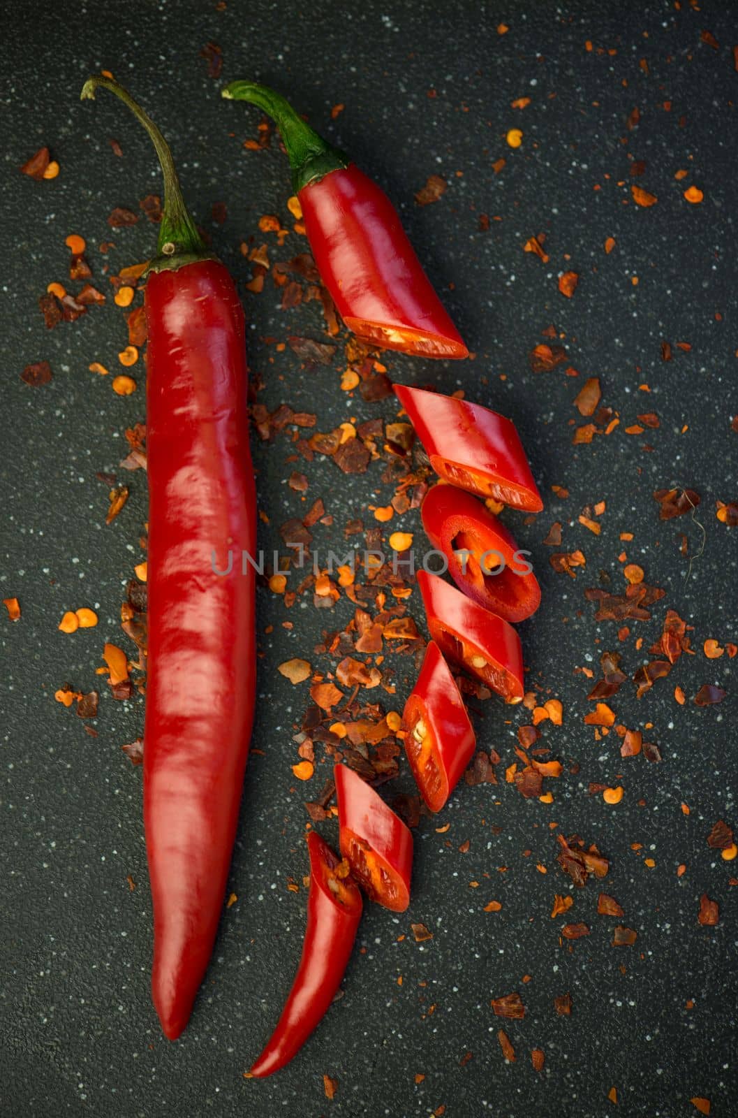 Red chili pepper cut into pieces on a black background. Hot spice, red chili