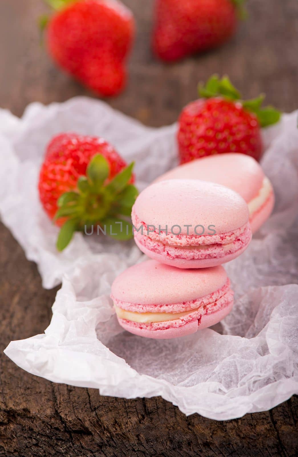 macarons with strawberries. Macaroon with raspberries cookies on a wooden background by aprilphoto