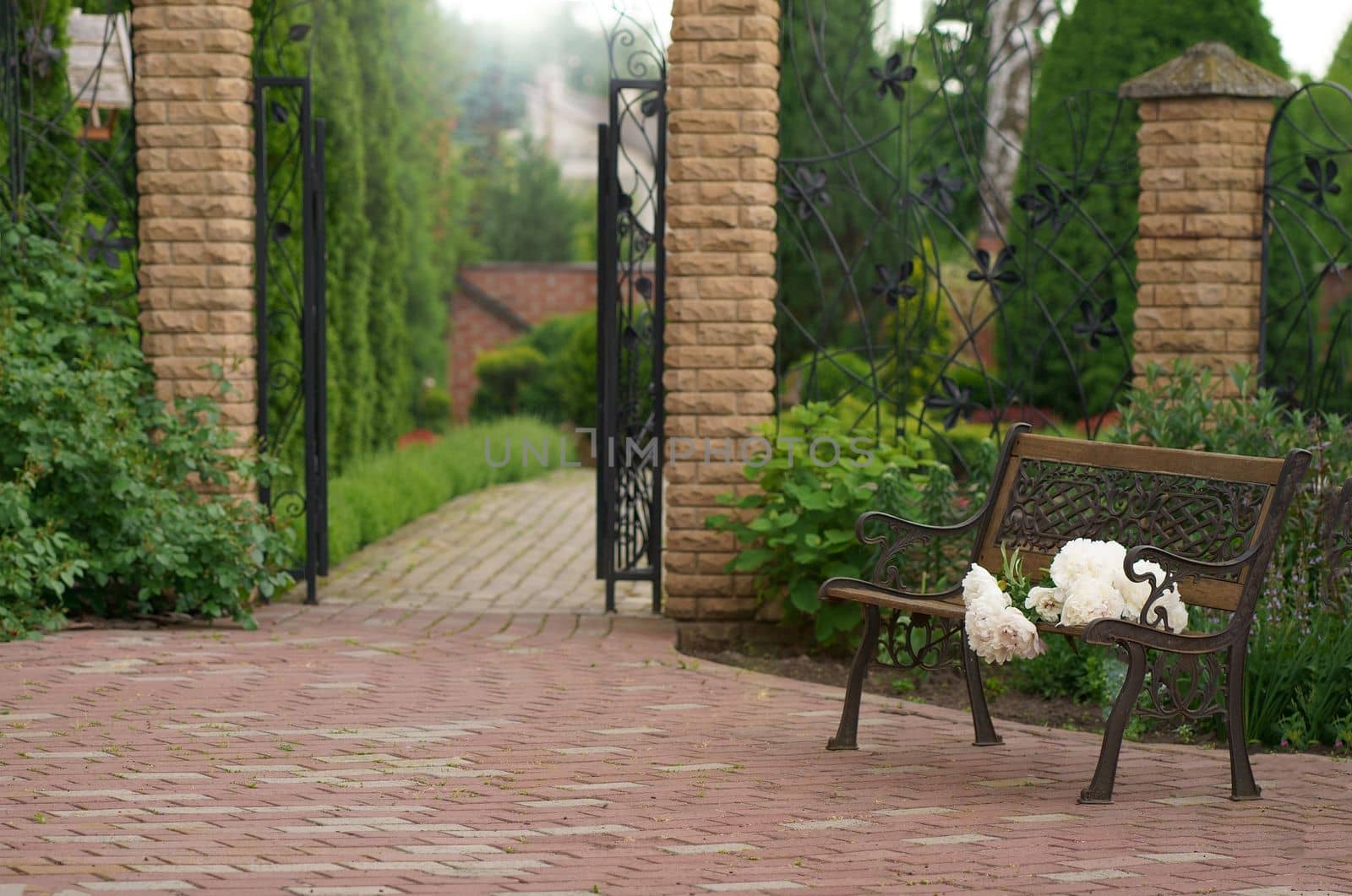 flower garden and vintage bench. A bouquet of peonies on a bench near a private house