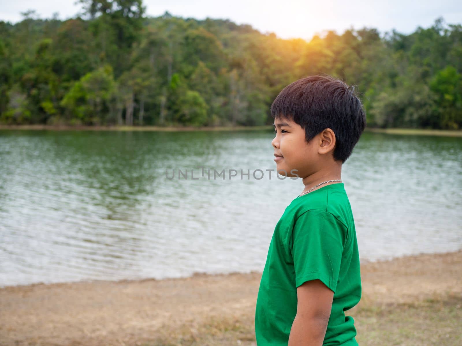 A boy stands by the reservoir in the evening. It shows looking at the goals in life. by Unimages2527