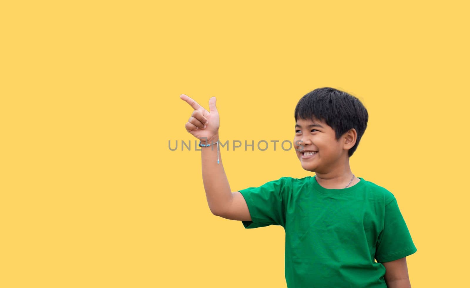 The boy smiled and pointed his hand to his side. on a yellow background