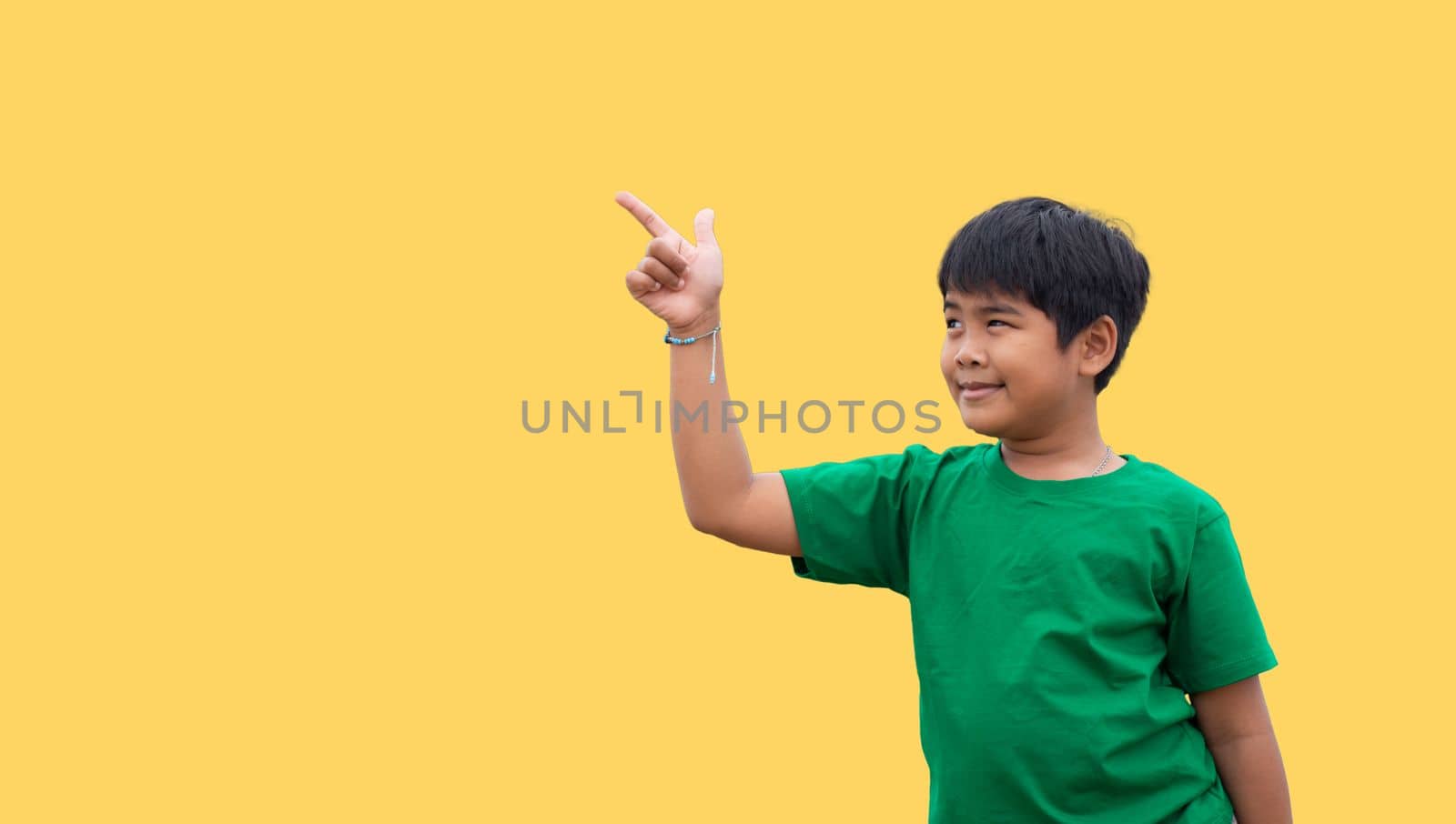 The boy smiled and pointed his hand to his side. on a yellow background