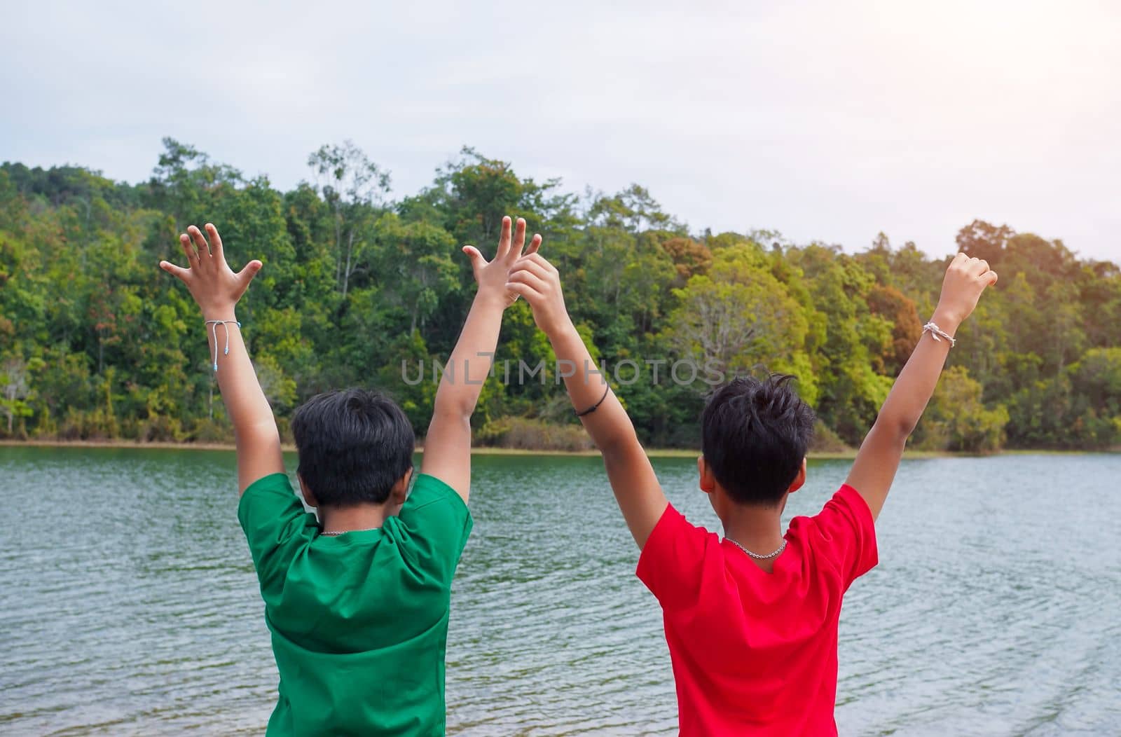 two brothers holding hands Standing on the banks of the reservoir. The concept of family love. by Unimages2527