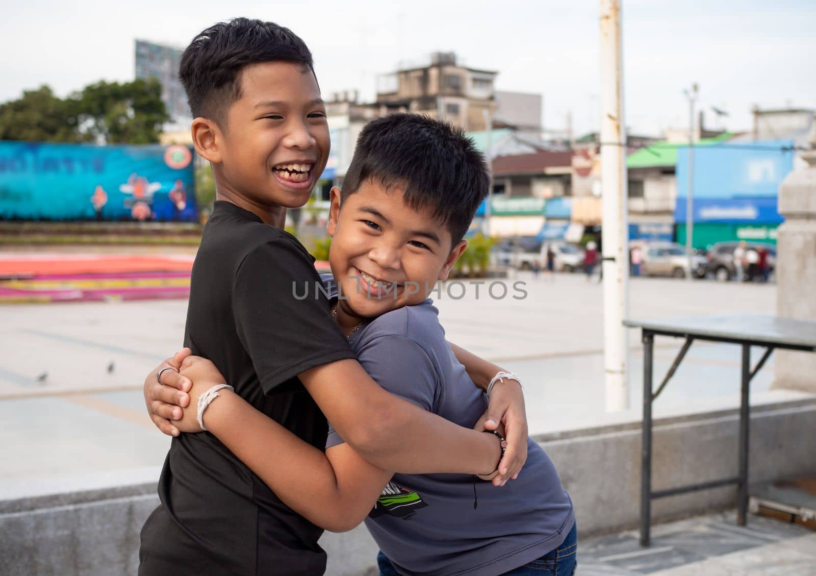 Brothers hugging each other and smiling happily