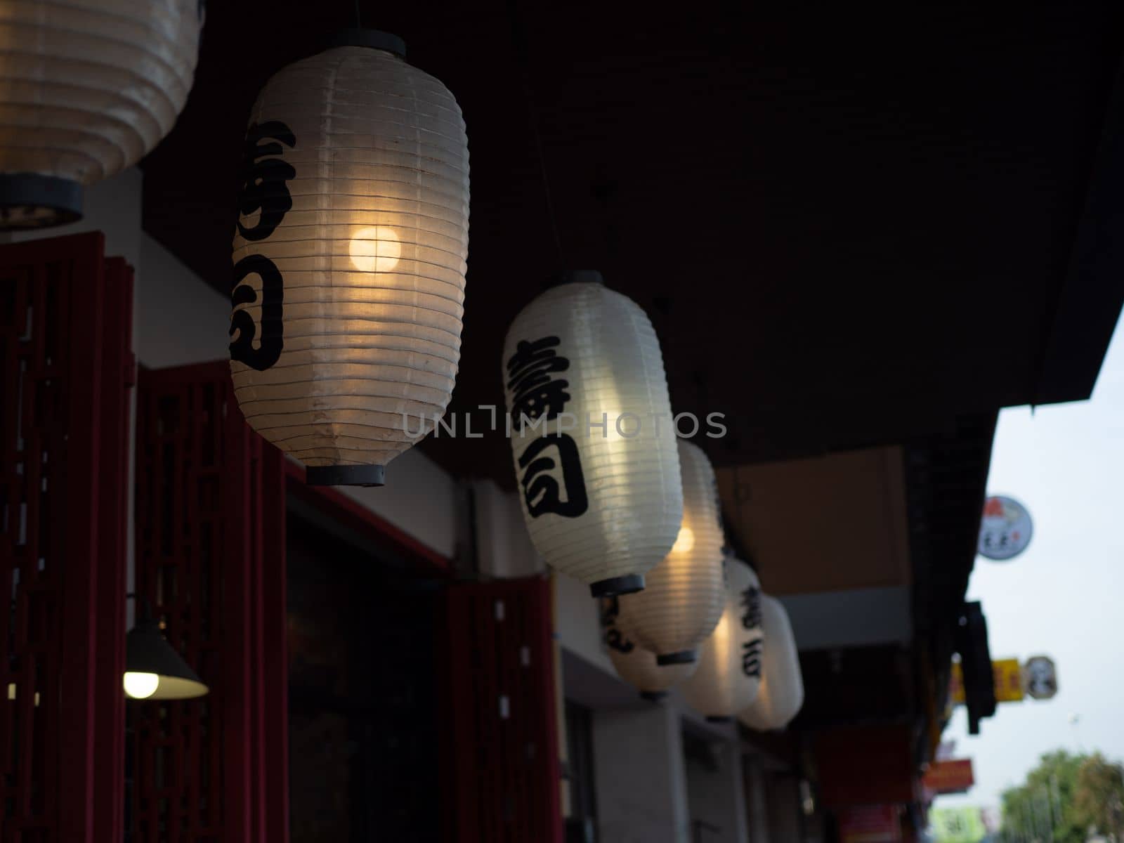 Japanese lantern hung in front of Japanese Restaurant, Japanese text on lantern is "Sushi" Japanese food.
