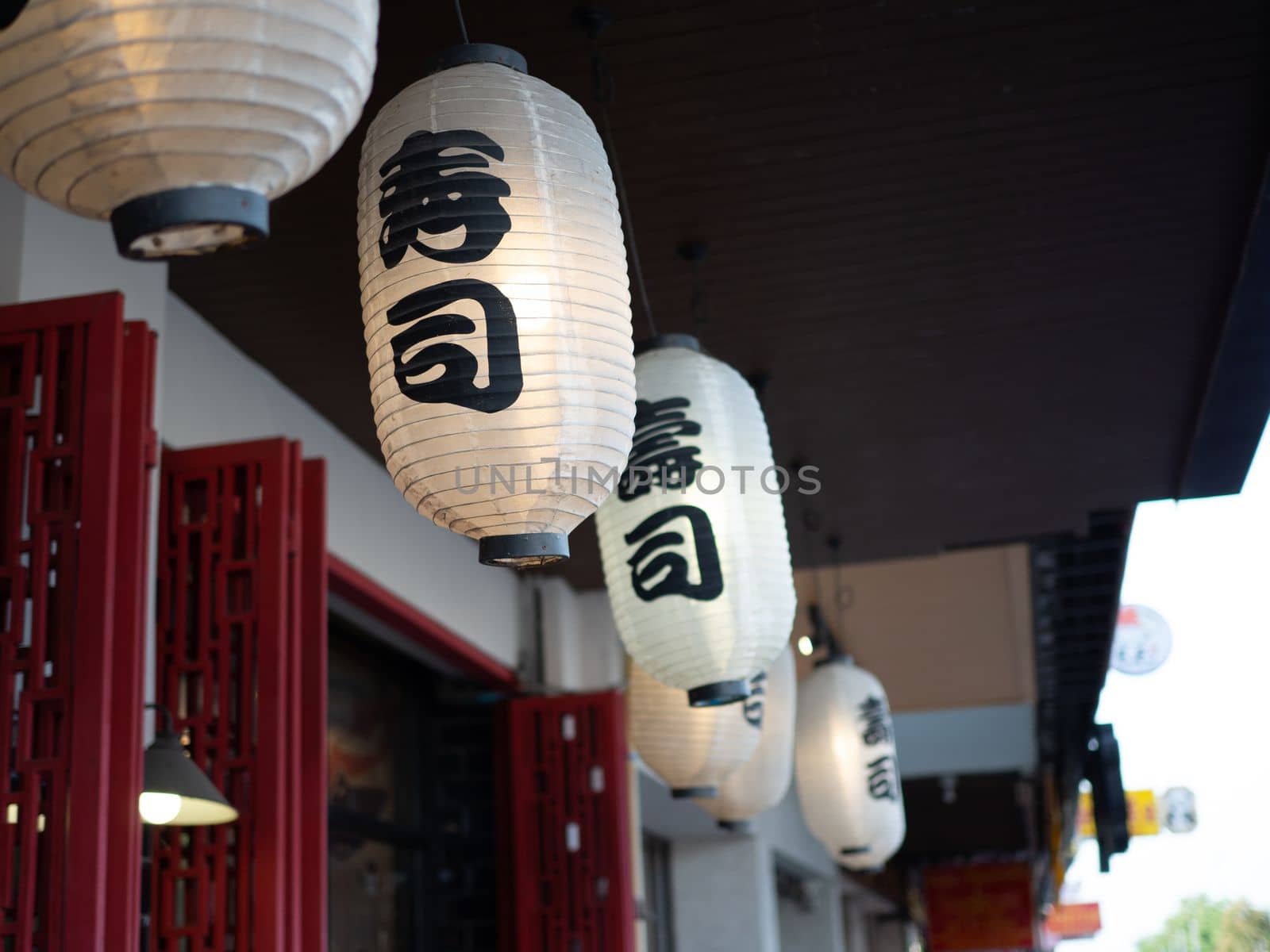 Japanese lantern hung in front of Japanese Restaurant, Japanese text on lantern is "Sushi" Japanese food.