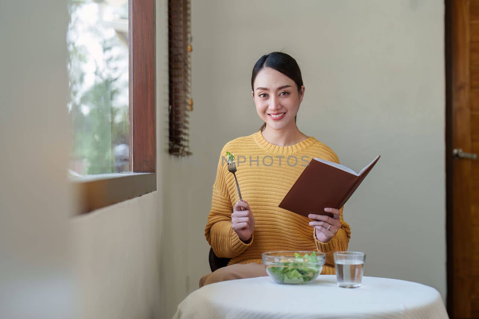 young attractive asian woman in eating salad. vegetables, tomatoes, cabbage, lettuce, cucumbers on table cooking healthy vegetable salad, healthy food active life.