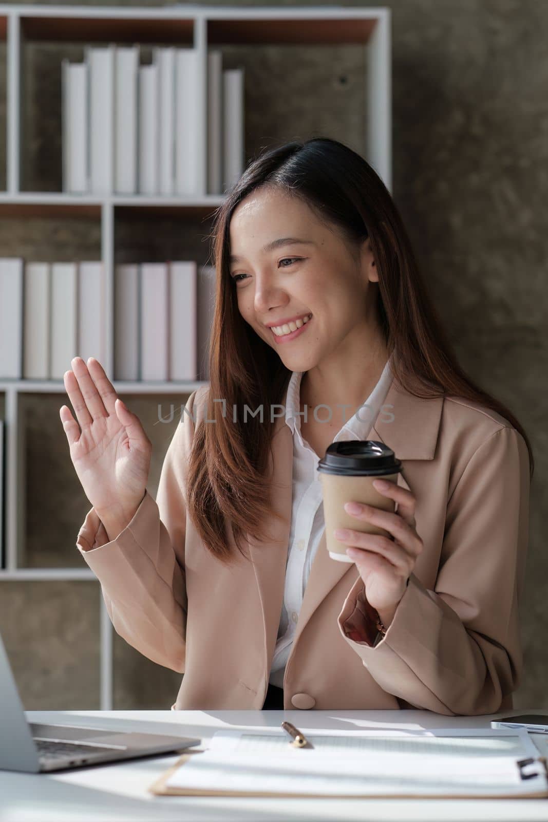 Smiling asian business woman with laptop computer in office. Woman in suit at office by itchaznong