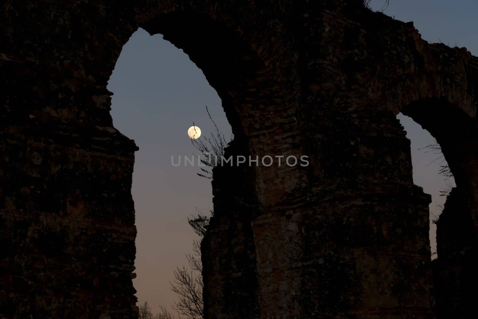 stone arches with full moon in the background by joseantona
