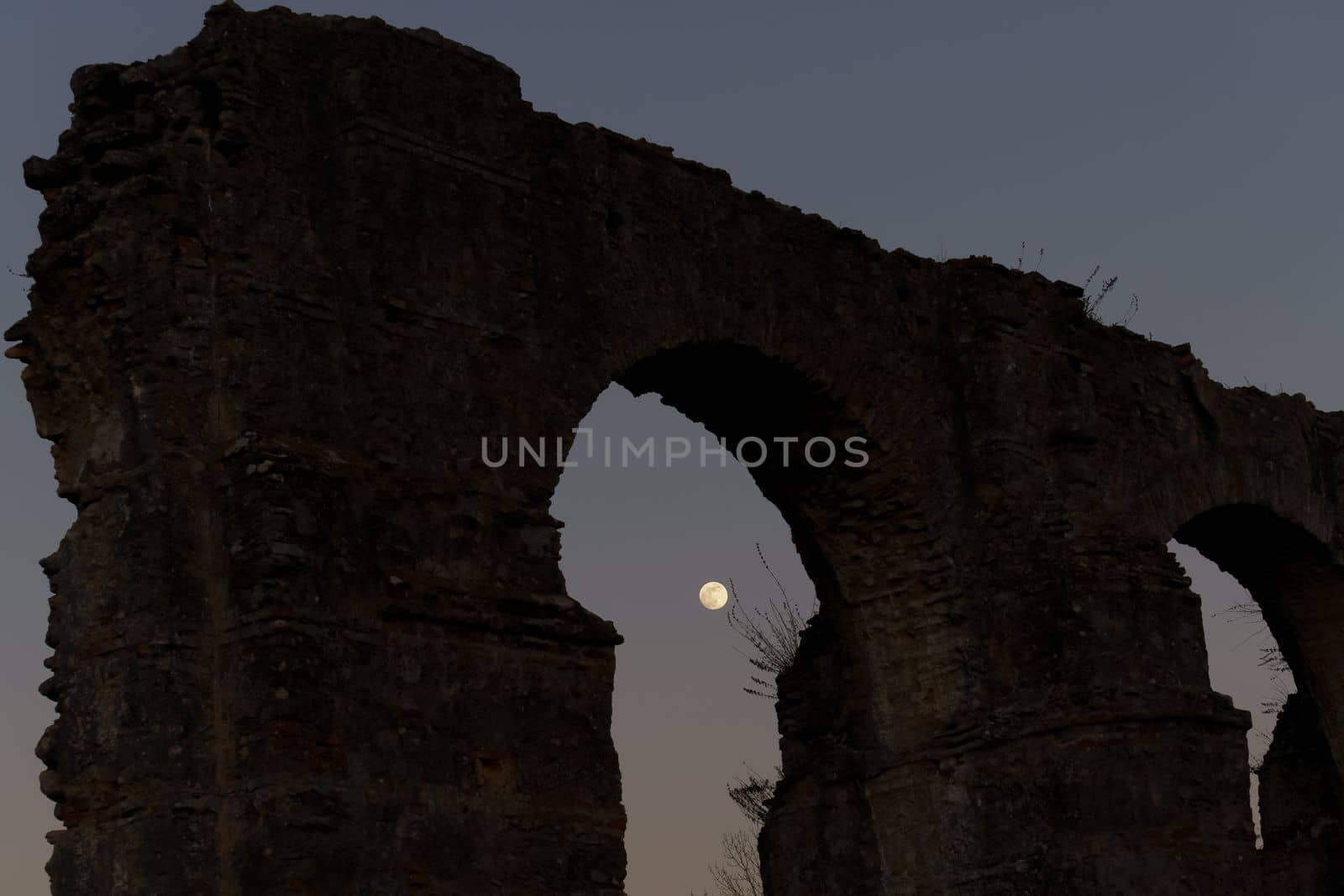 stone arches with full moon in the background by joseantona