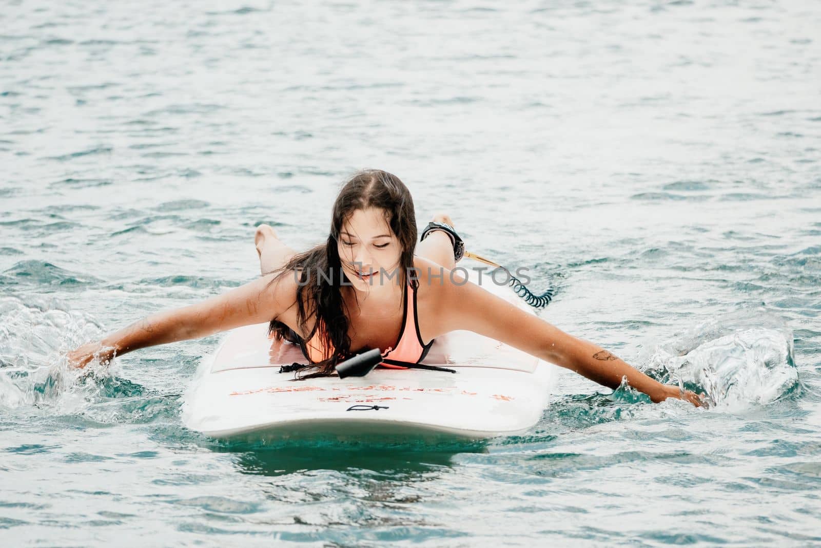 Sea woman sup. Silhouette of happy young woman in pink bikini, surfing on SUP board, confident paddling through water surface. Idyllic sunset. Active lifestyle at sea or river. Slow motion