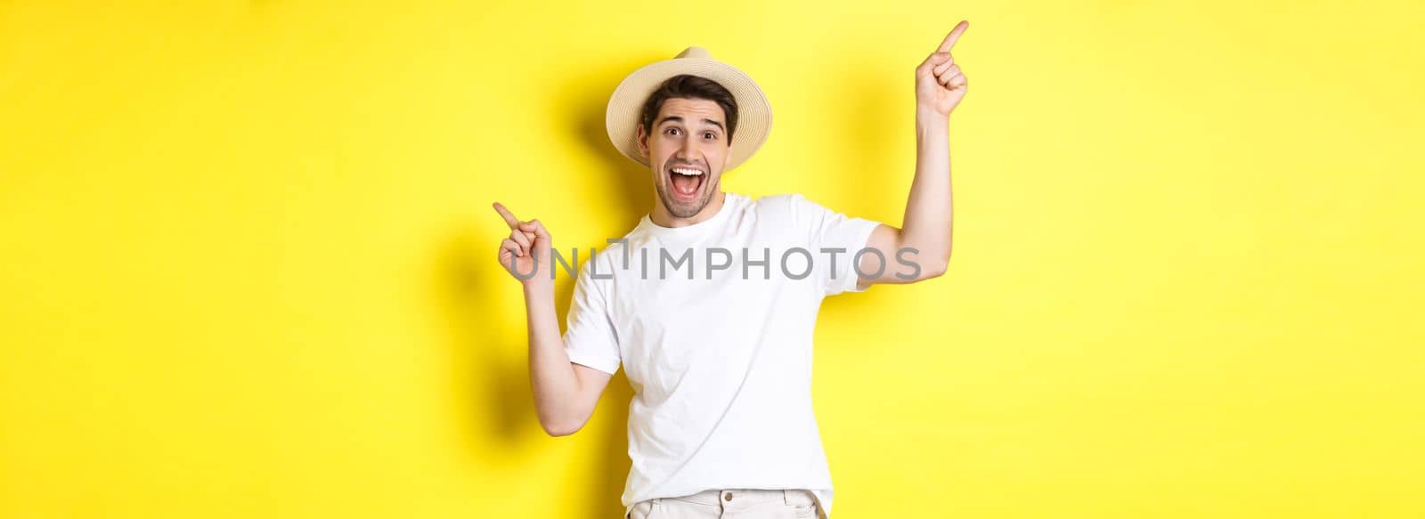 Concept of tourism and lifestyle. Happy tourist dancing and pointing fingers sideways, showing vacation variants, yellow background.