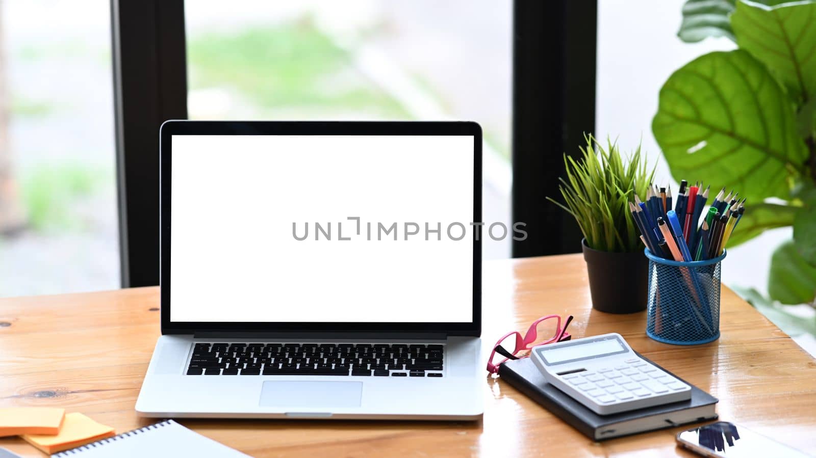 Laptop computer, calculator and paperworks on wooden table. by prathanchorruangsak