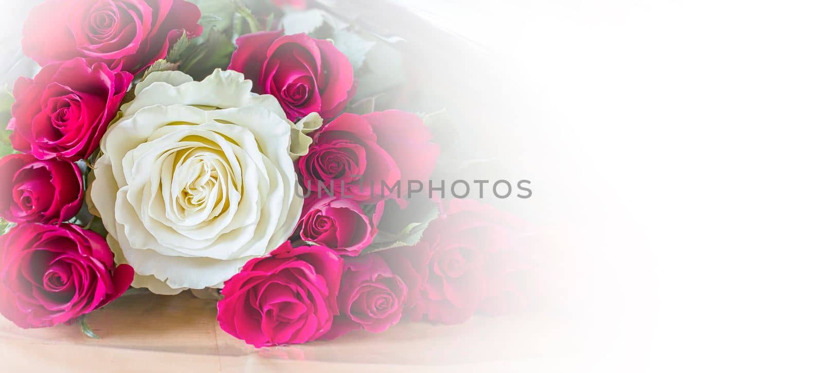 Beautiful bouquet of une white and red roses on table close-up with copy space. Banner