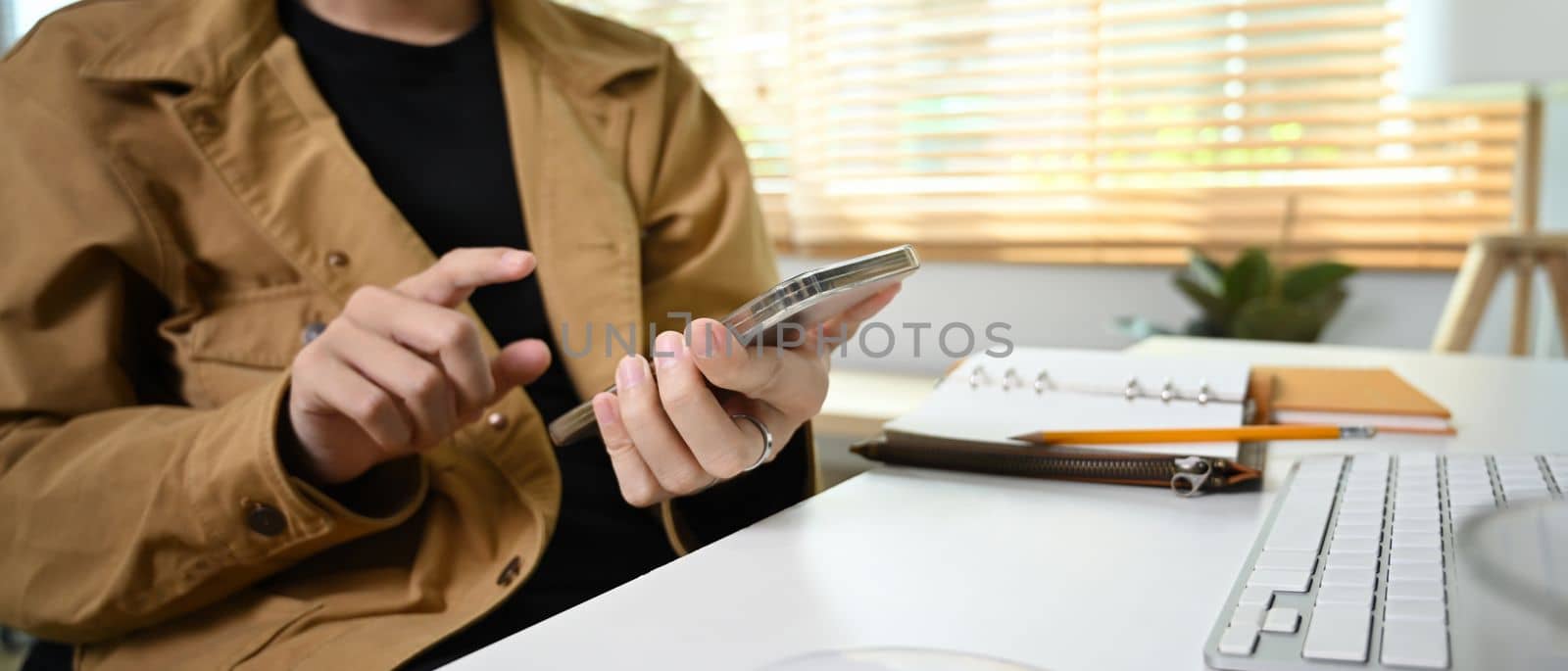 Man freelancer using smart phone while sitting in living room.
