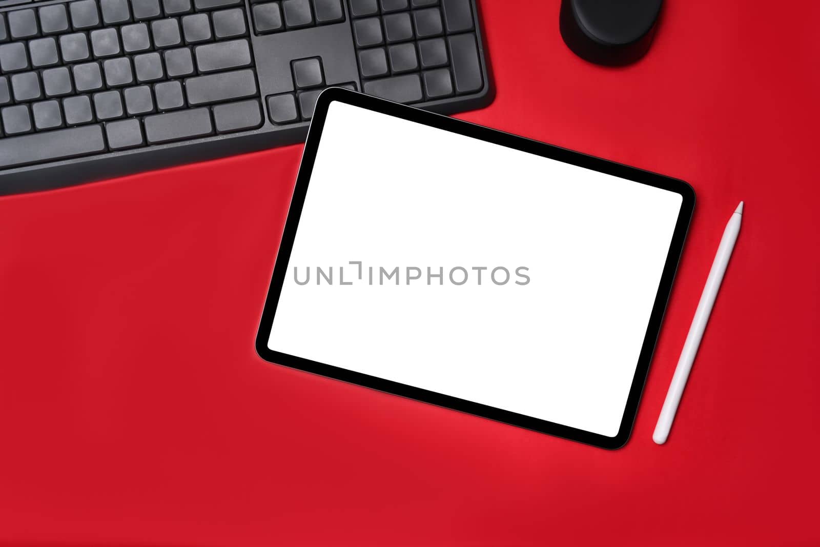 Top view digital tablet with empt display on red background.