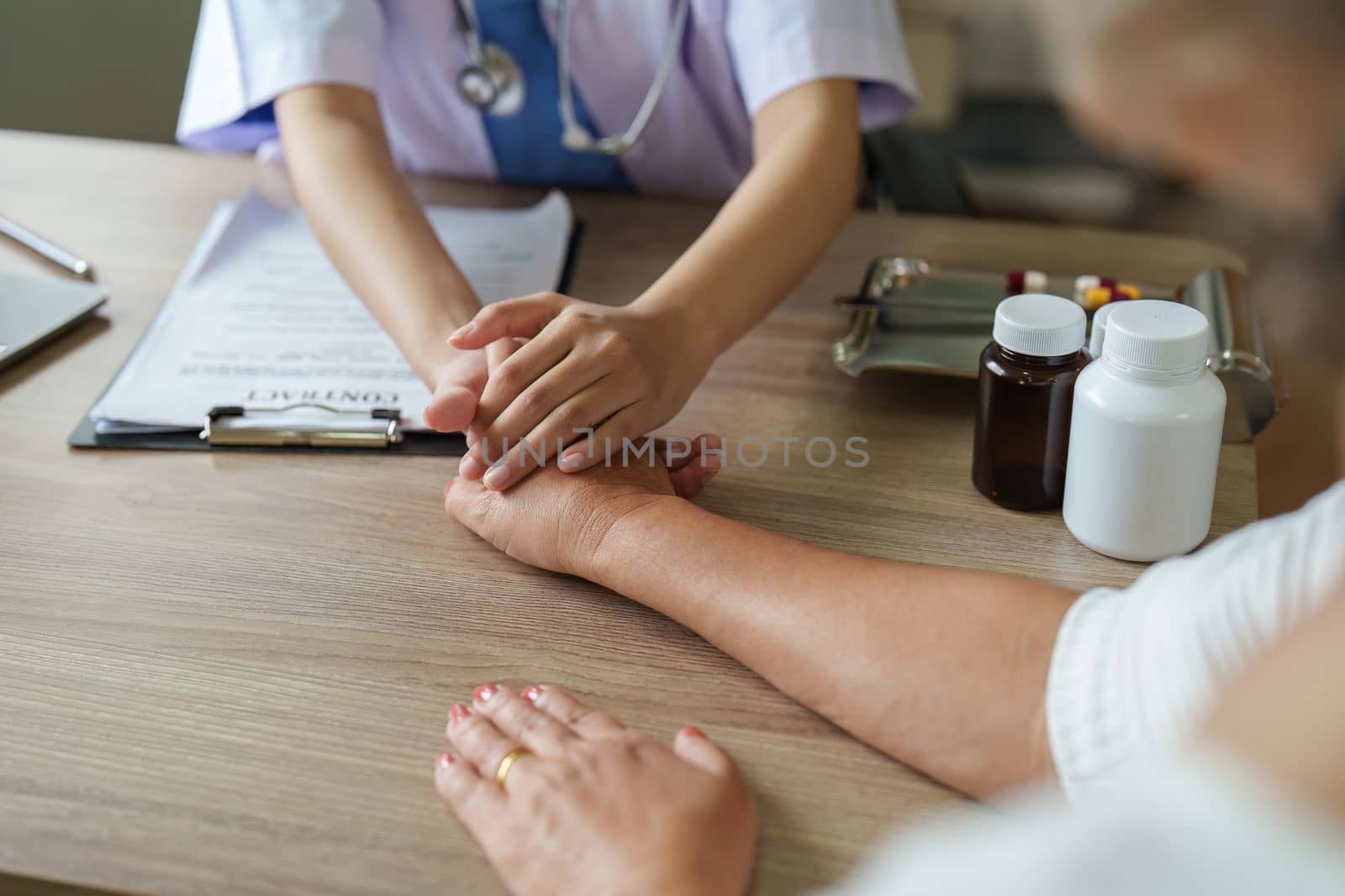 Doctor giving hope. Close up of doctor holding hand of elderly lady patient. Home healthcare nurse, physical therapy with senior adult woman.