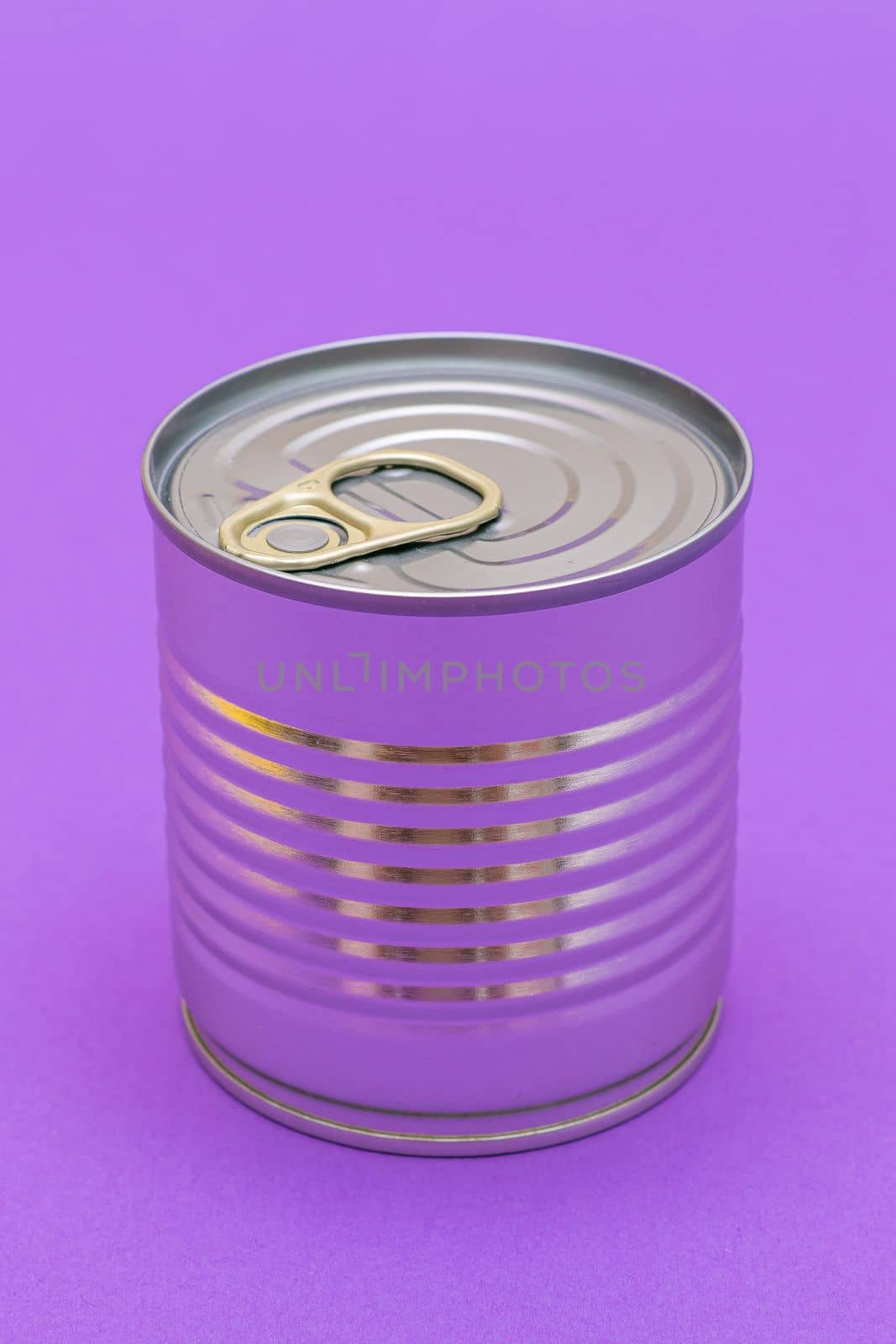 Unopened Tin Can with Blank Edge on Violet Background. Canned Food. Aluminum Can for Safe and Long Term Storage of Food. Steel Sealed Food Storage Container