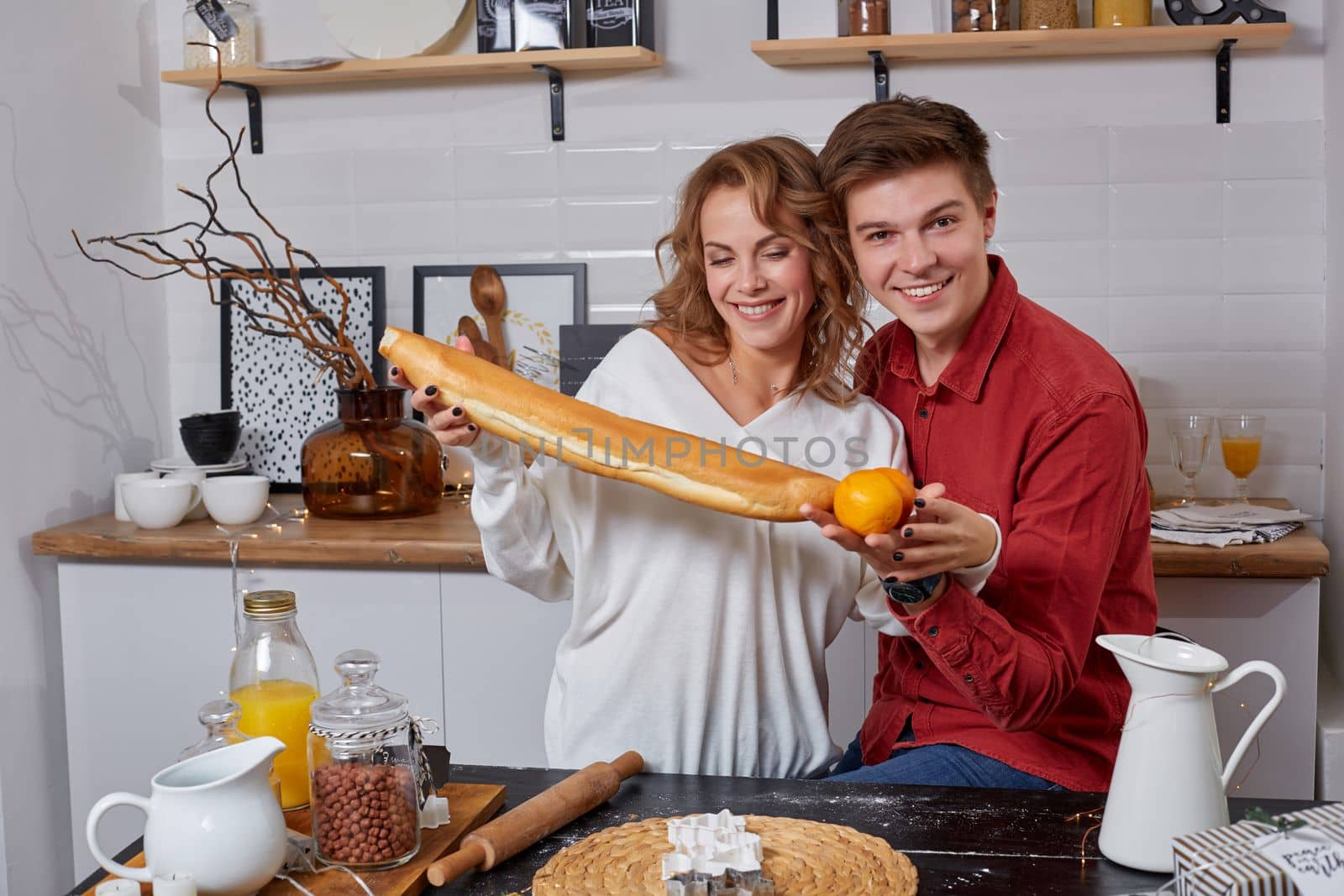 Happy young lovely couple on kitchen hugging each other. They enjoy spending time togehter by nazarovsergey