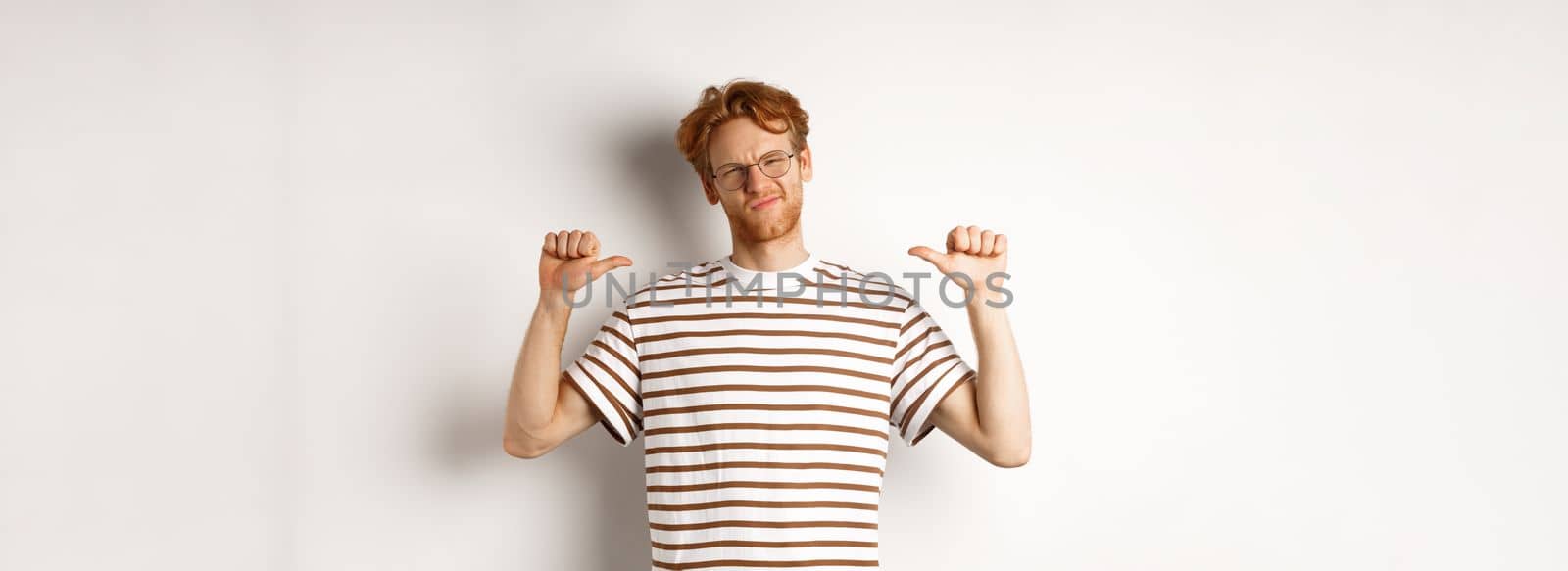 Confident young nerdy guy in glasses with red hair, pointing at himself and looking like professional, white background by Benzoix