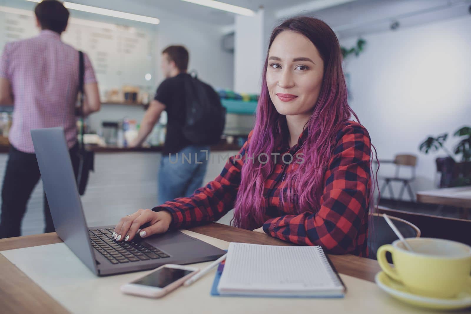 Young woman with pink hair with laptop computer sitting in cafe, by nazarovsergey