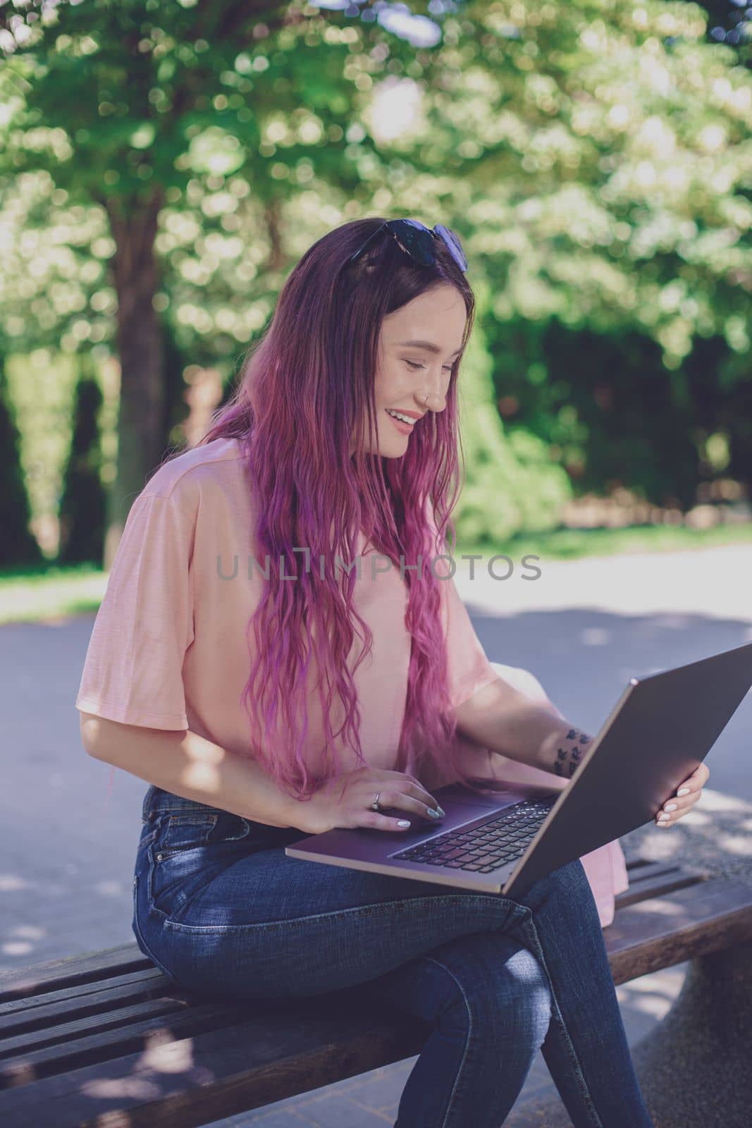 Young girl is studying in the spring park, sitting on the wooden by nazarovsergey