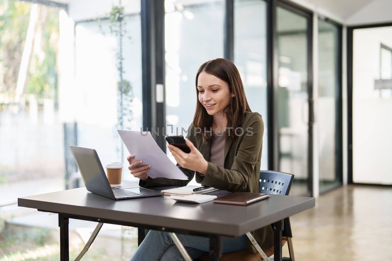 Smiling asian business woman with smartphone in office. Woman in casual at office by itchaznong