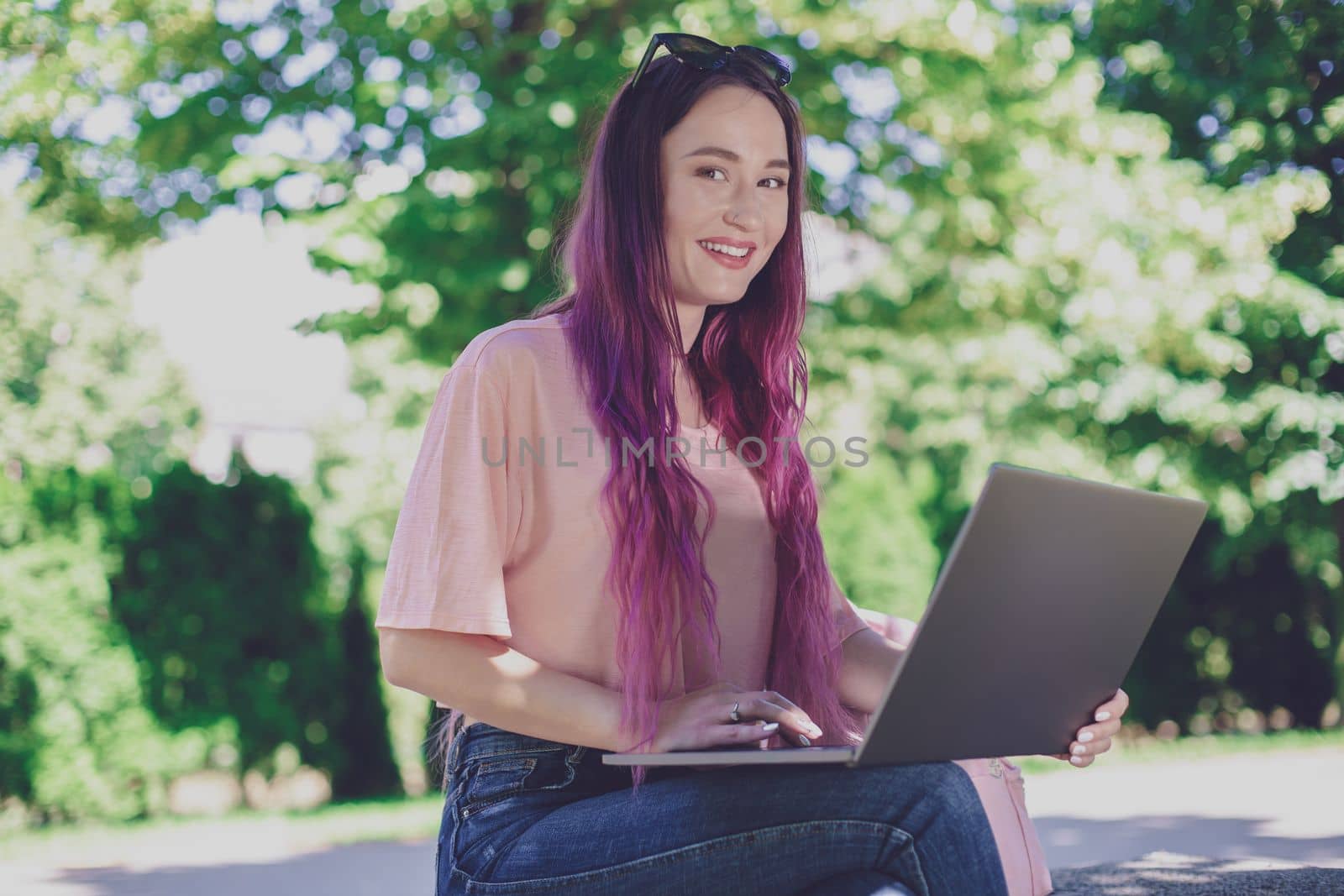 Young girl is studying in the spring park, sitting on the wooden by nazarovsergey