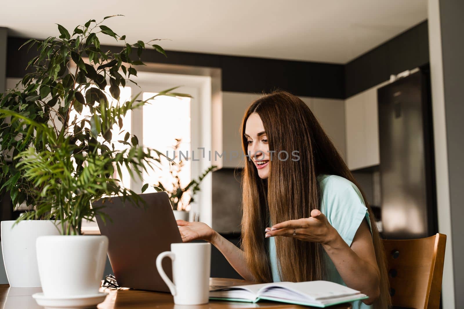 Girl manager with laptop gesticulates, discuss trends and tasks at home. Online video meeting with colleagues and business partners. Team discussion and problem solving remotely