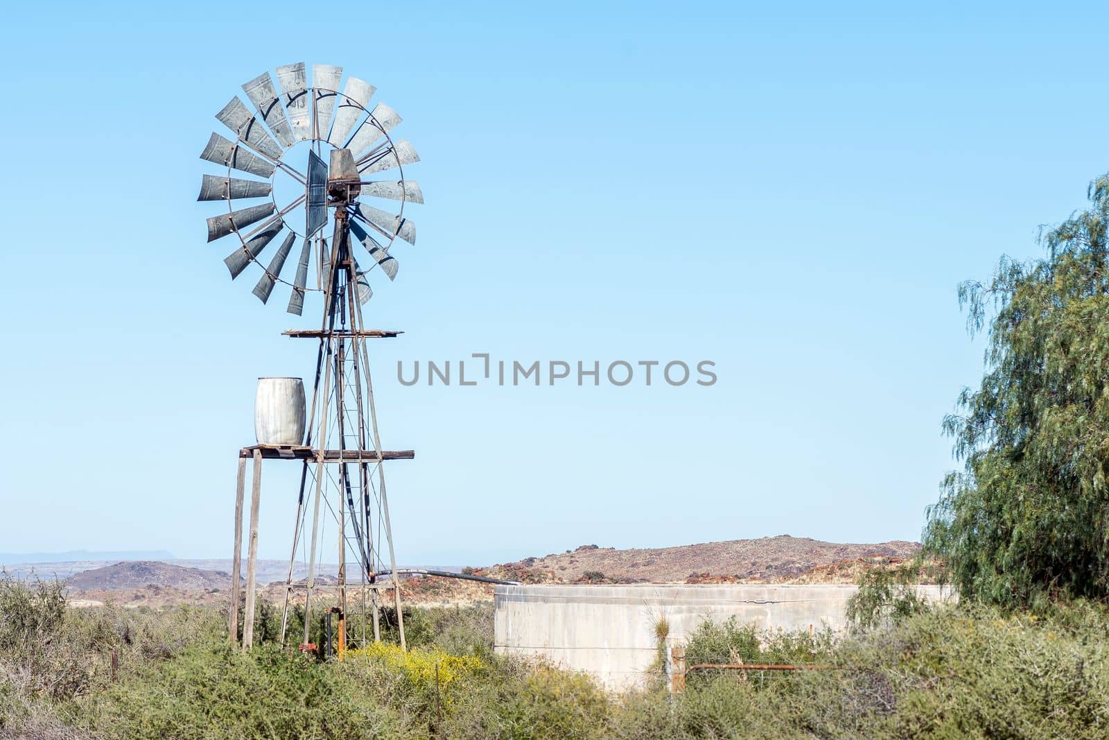 A typical Karoo landscape, with a windmill, water tank and dam, on road R356 between Loxton and Fraserburg in the Northern Cape Karoo
