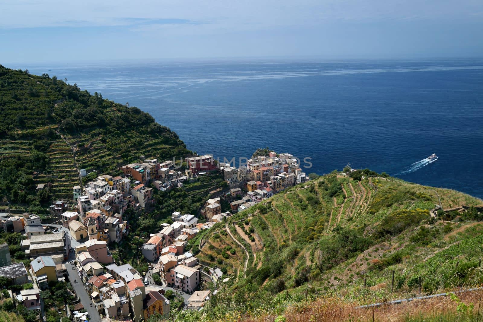 View over one of the famous villages on the picturesque coast of the Cinque Terre region with the blue sea in the background.