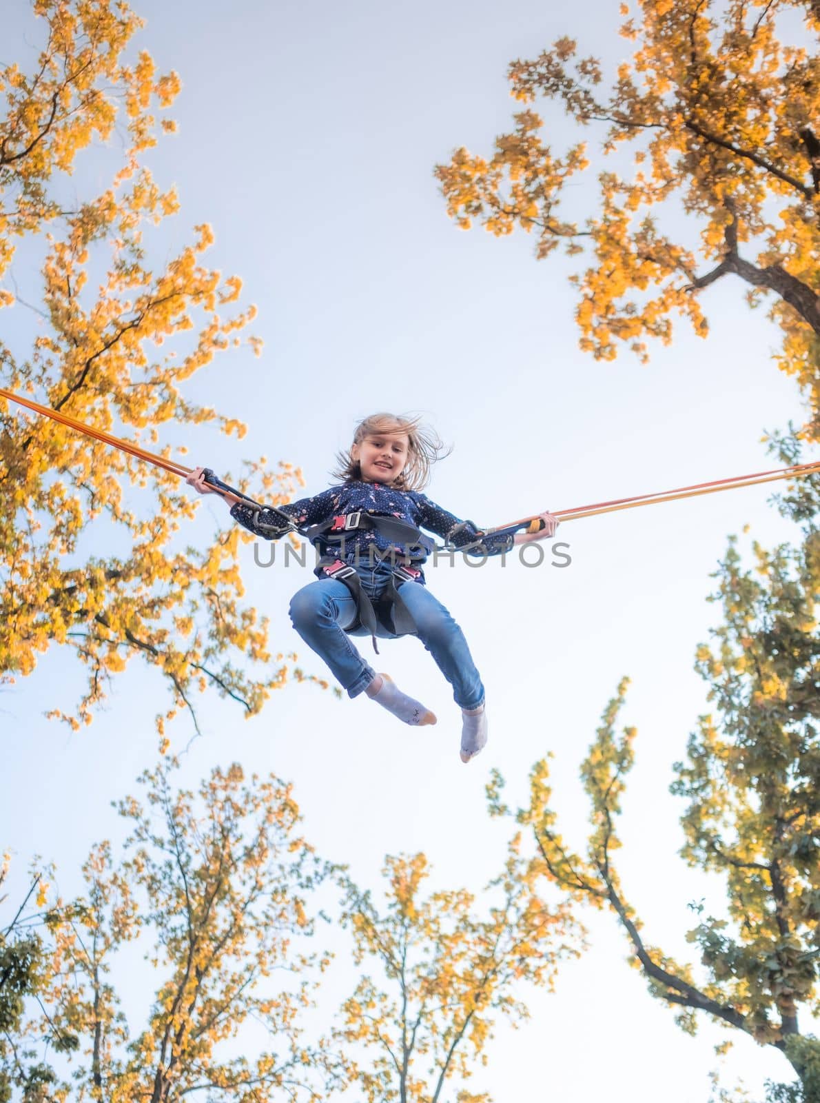 Little girl on trampoline jumping ropes by GekaSkr