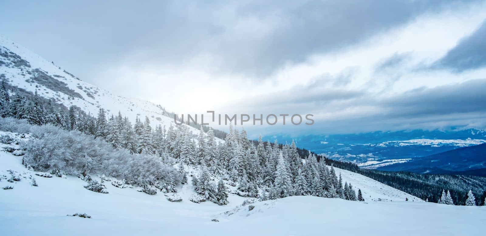 Scenic landscape of winter mountain range under cloudy sky