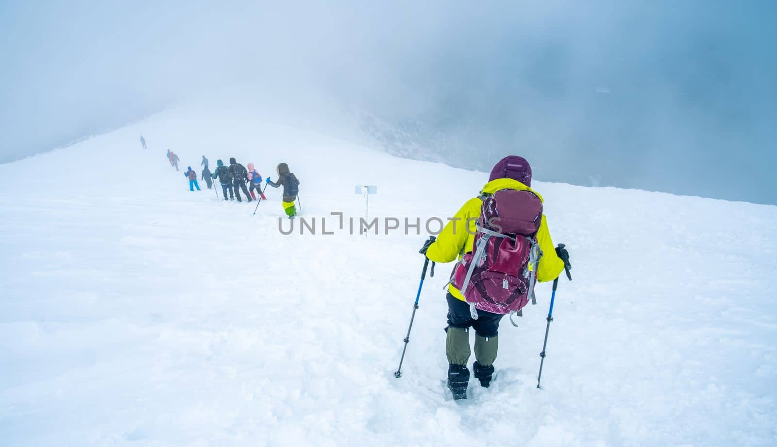 Tourist group descending after conquering winter mountain