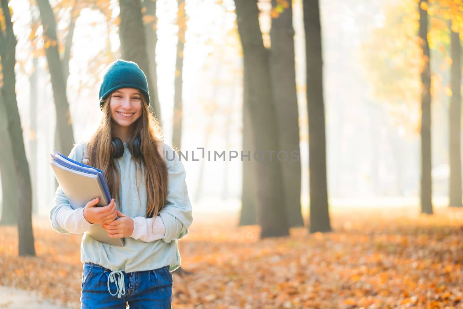 Happy school girl in autumn park by GekaSkr