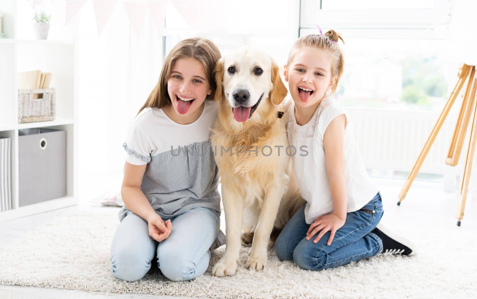 Funny Portrait of little girls with cute dog in bright room