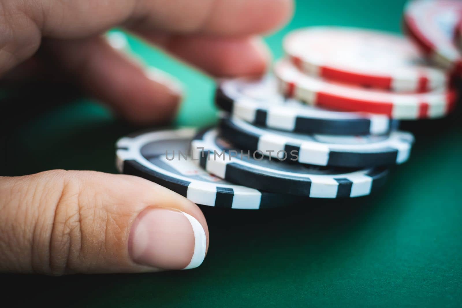 Casino tokens under girl hand on poker table