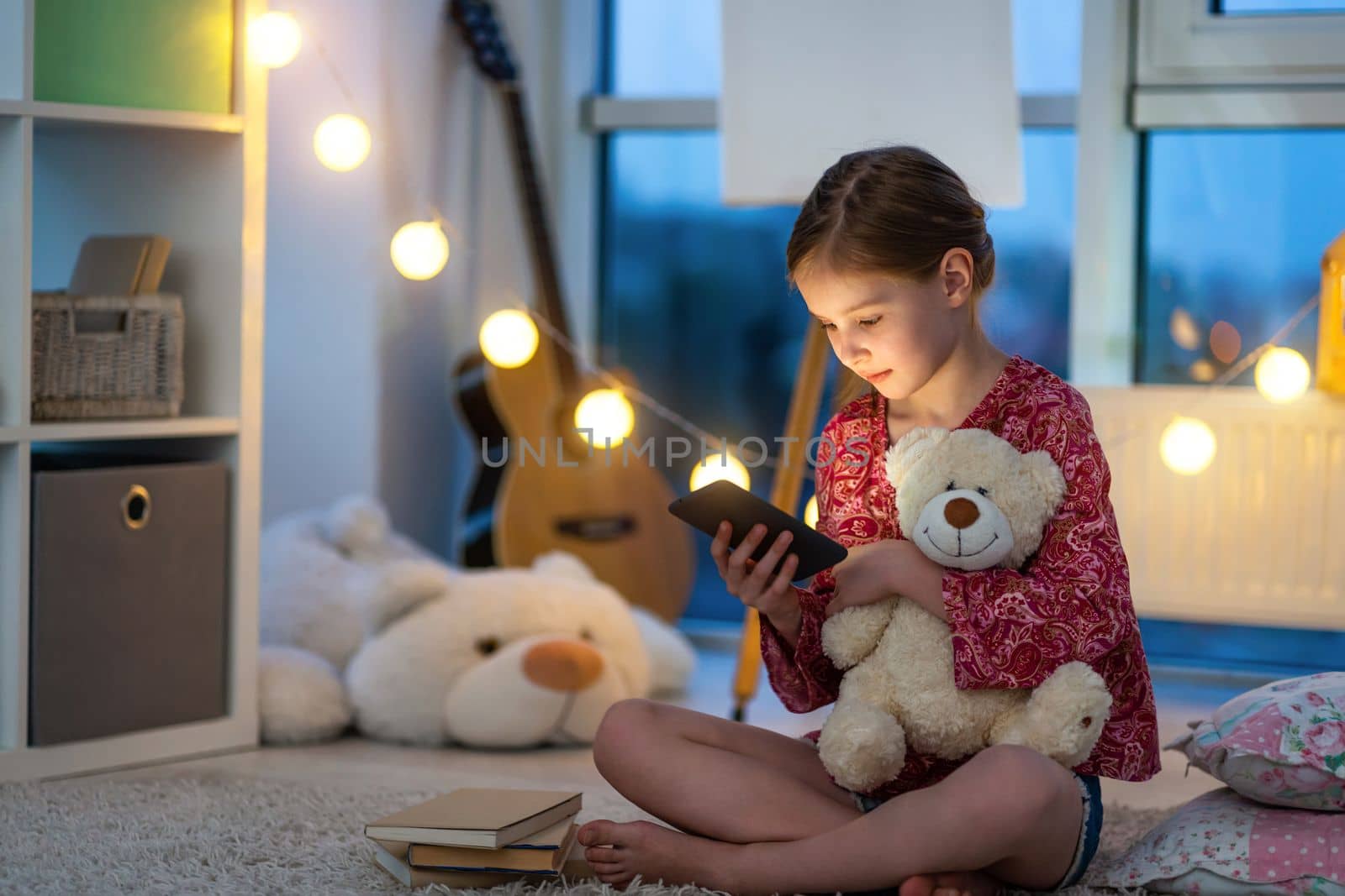 Little girl with smartphone in night room by GekaSkr