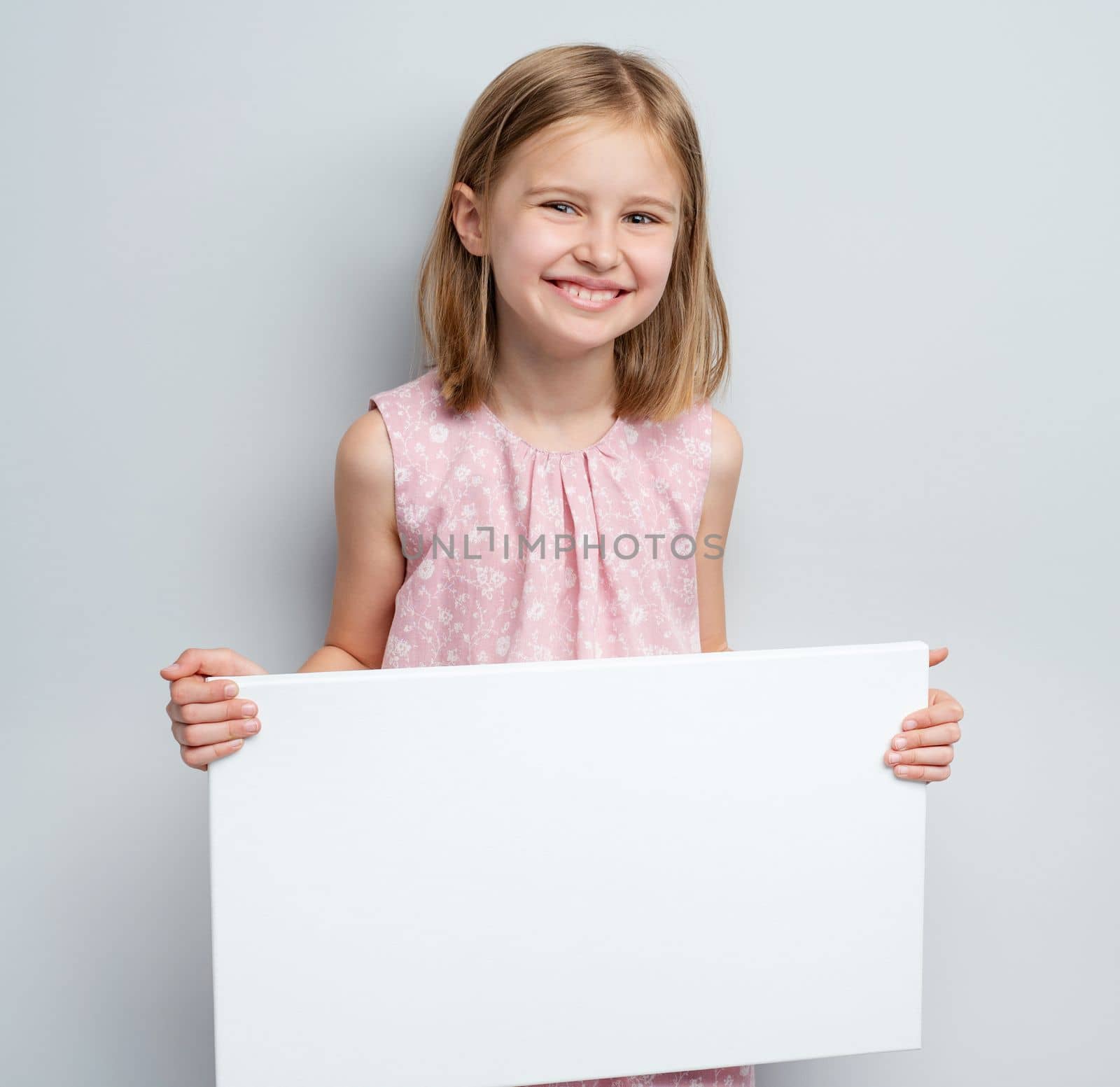 School girl holding horizontal blank white poster