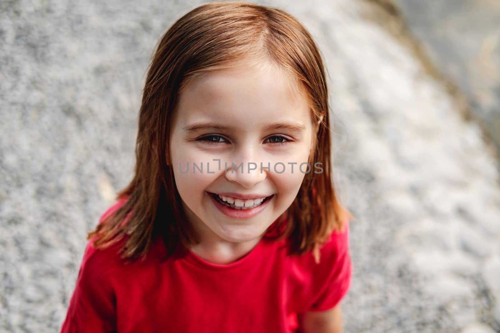 Portrait of smiling little girl looking up, top view