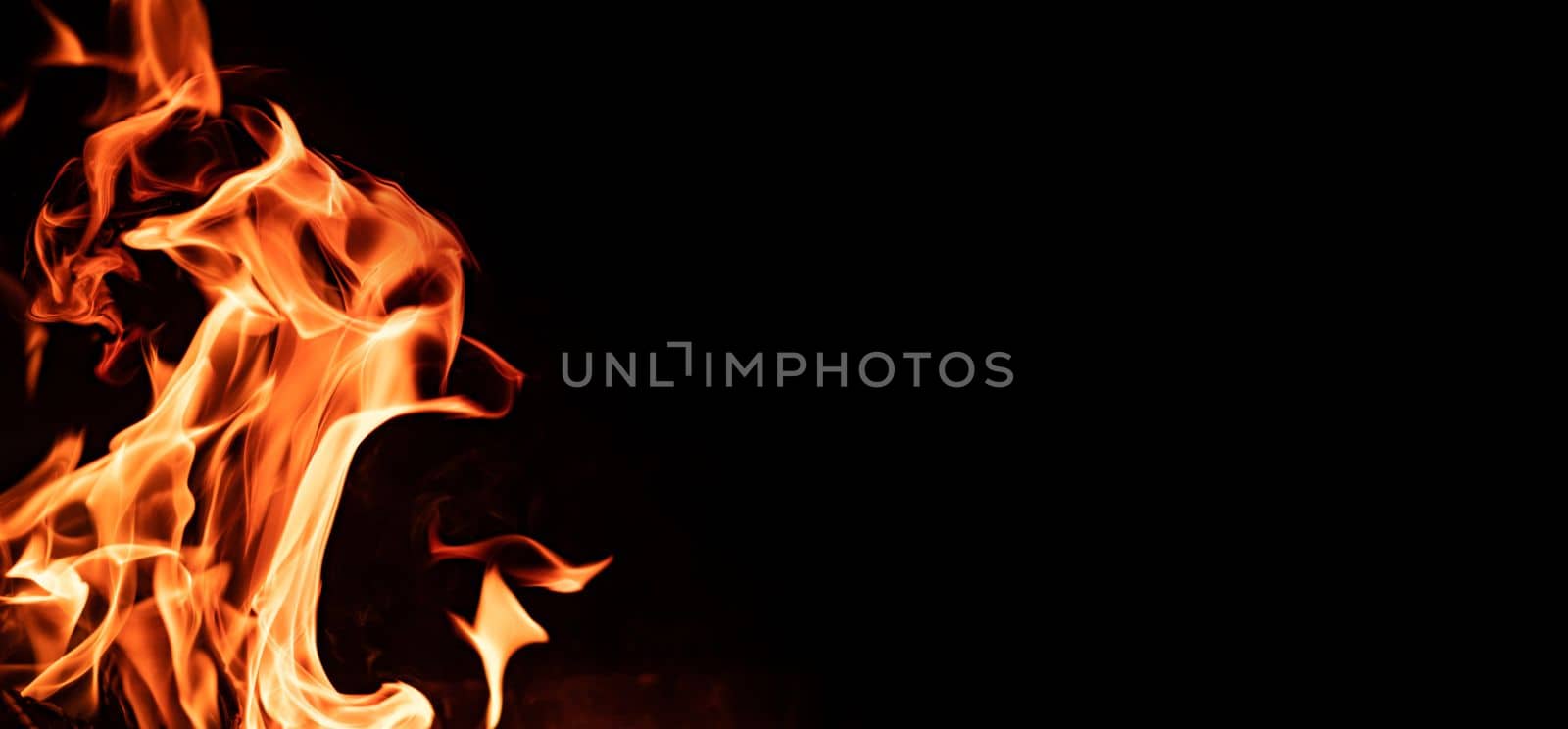 Beautiful abstract flame from bonfire on the nature in the night. Orange fire tonques isolated on black background