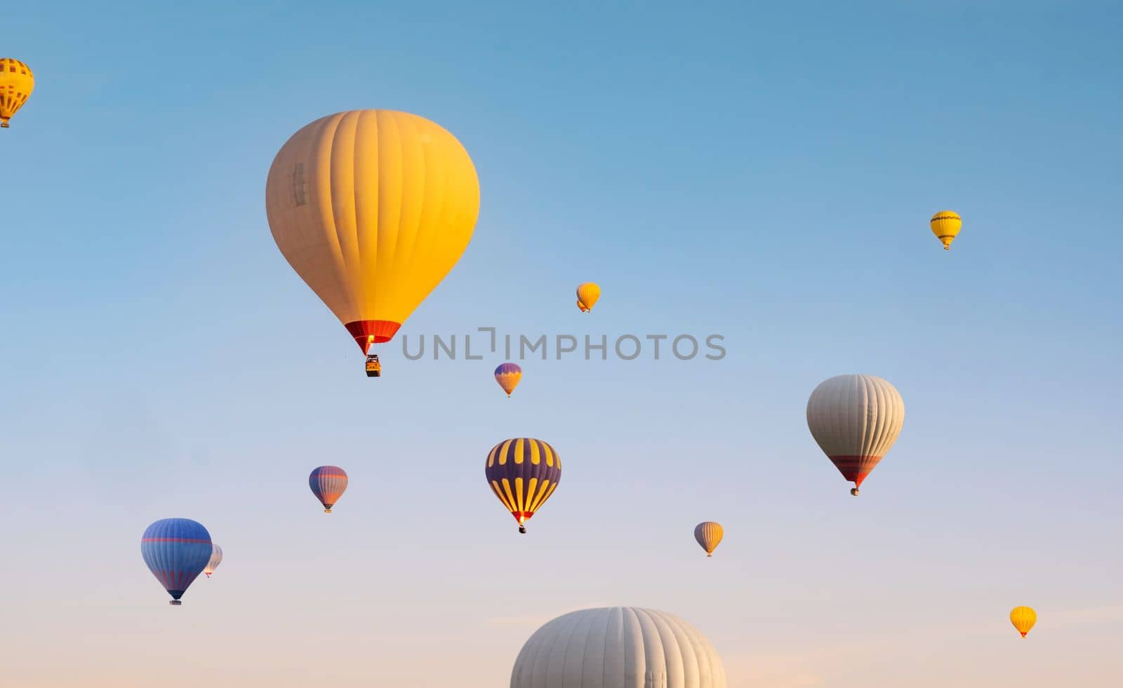 Colorful hot air balloons flying in clear blue sky
