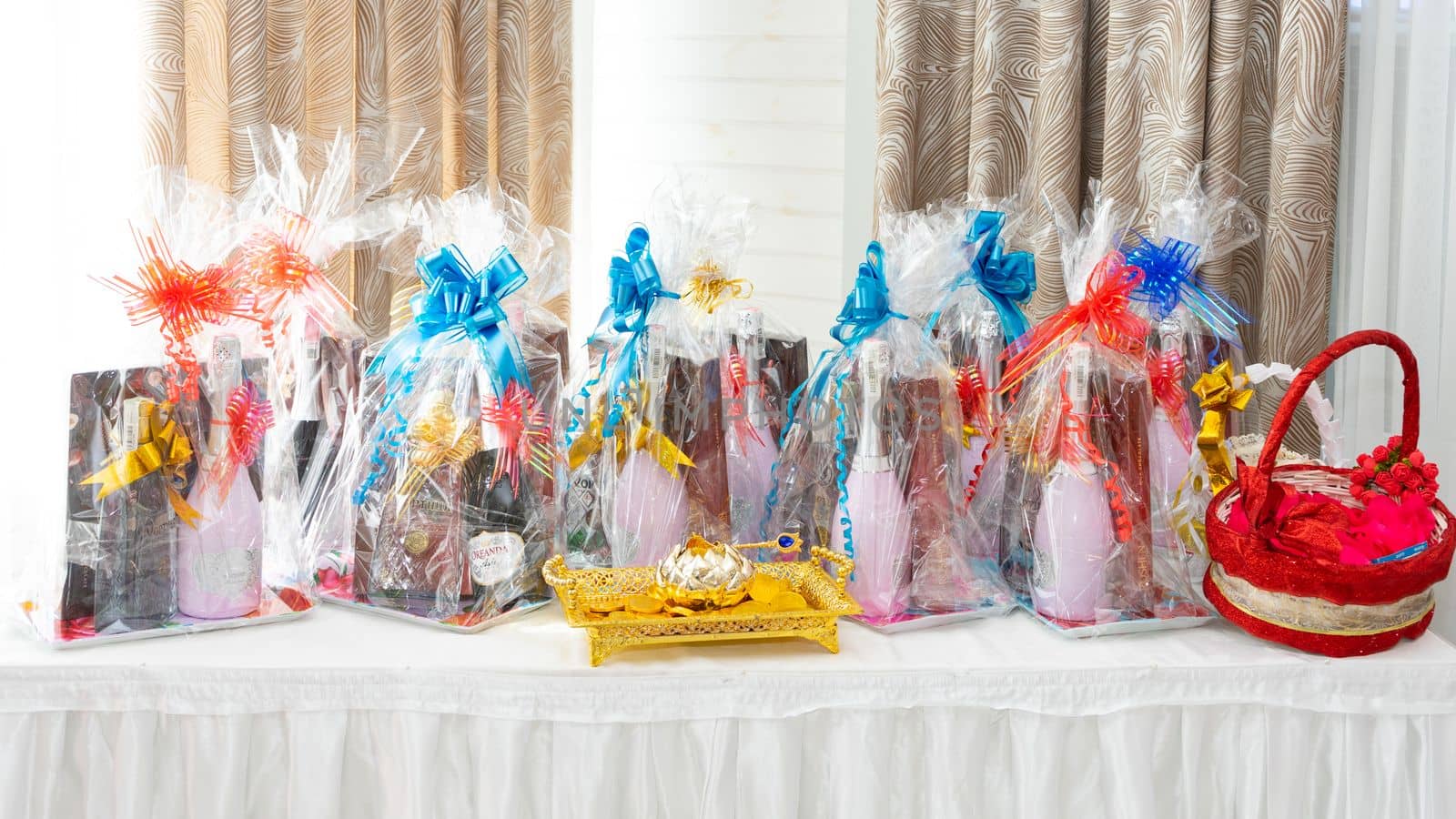 Many gifts on the table with a white tablecloth in the banquet hall. Table with gifts close-up. by Serhii_Voroshchuk