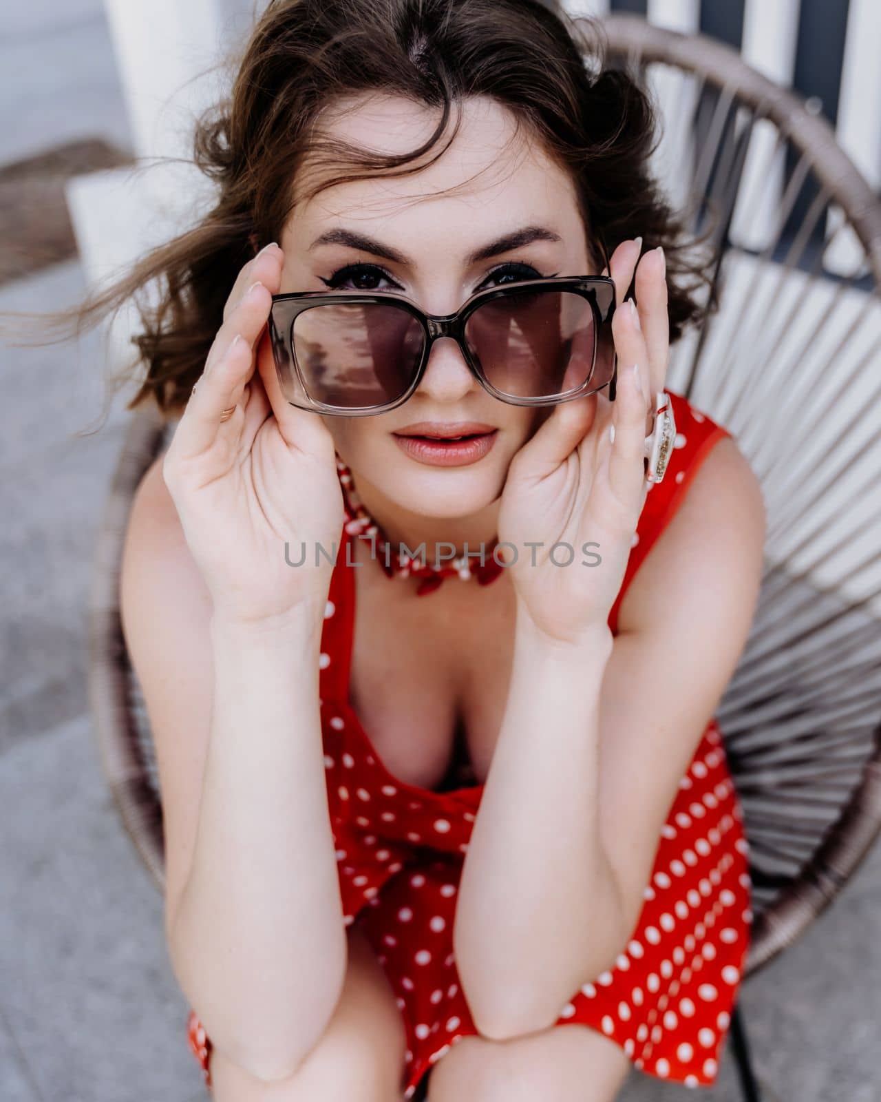 Close-up portrait of a woman with glasses. Photo of a fashionable girl with beautiful brown hair smiling at the camera. by Matiunina