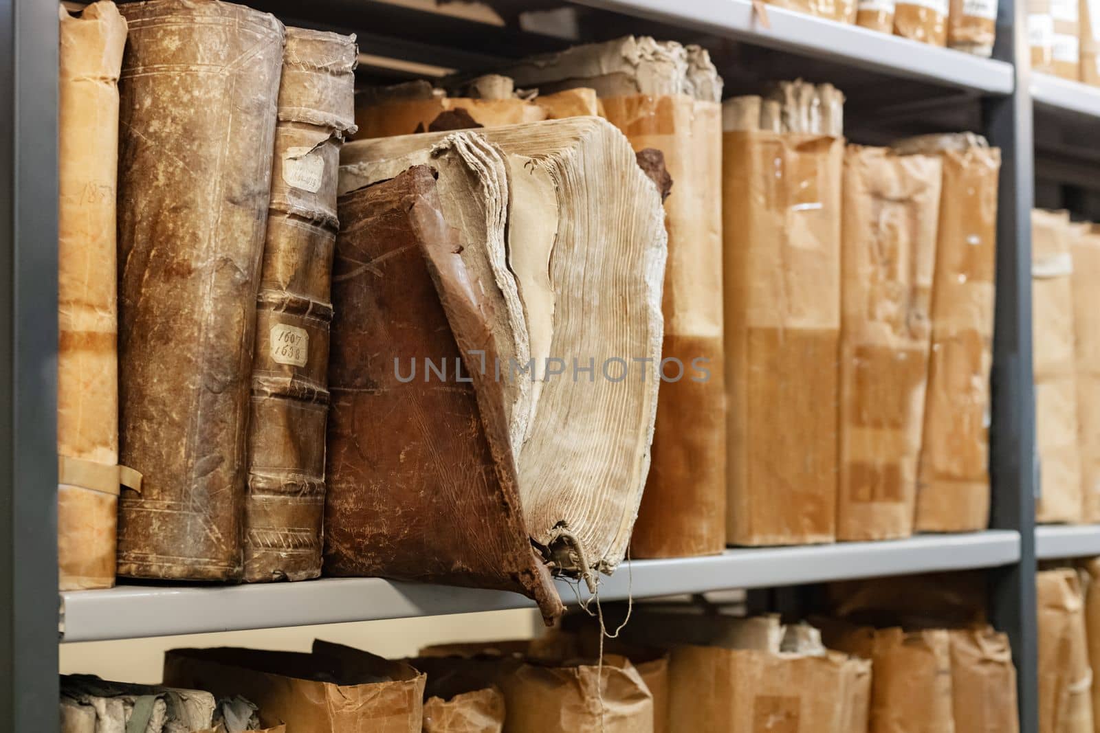 Old worn 17th century books on a shelf in the library's archives