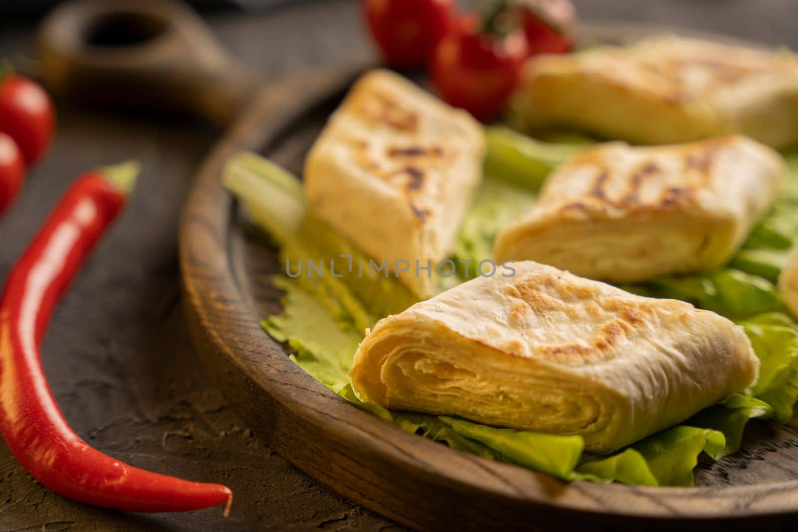 Delicious fried pita bread roll with cottage cheese and herbs. Fried puff rolls of thin Armenian lavash stuffed with cottage cheese. Wrapped tortillas. Traditional cuisine. Delicious and healthy food.