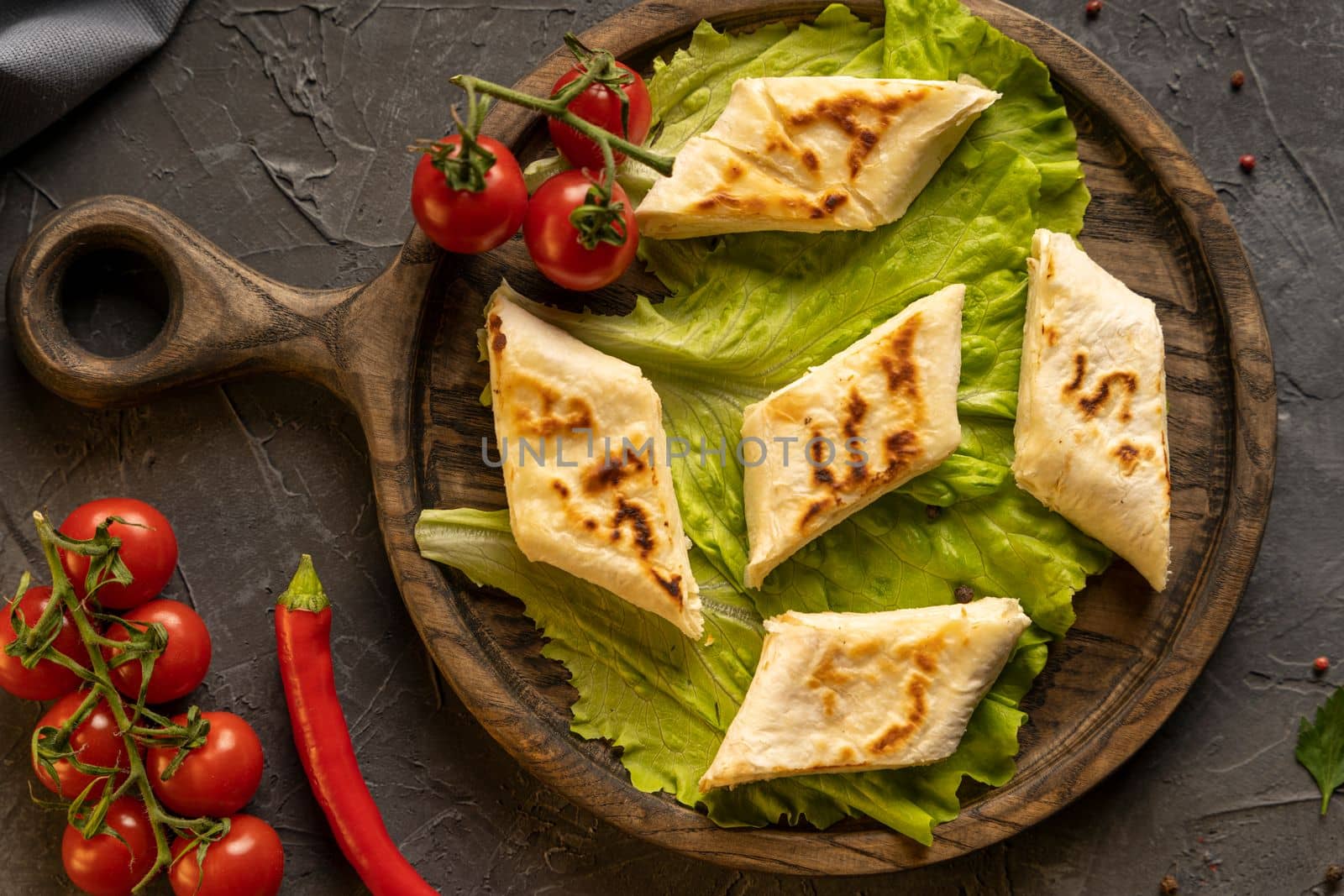Delicious fried pita bread roll with cottage cheese and herbs. Fried puff rolls of thin Armenian lavash stuffed with cottage cheese. Wrapped tortillas. View from above.